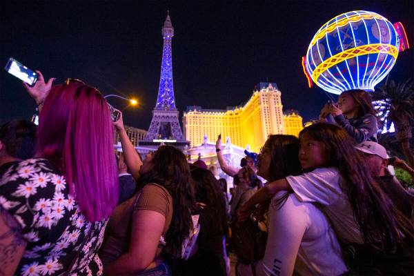 BTS fans watch as the Bellagio Fountain plays a show to songs “Butter” and &#x201 ...