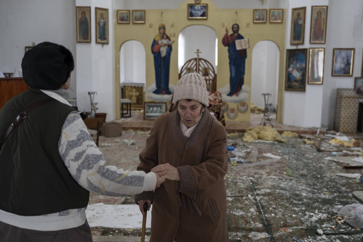 A woman reacts as she enters a damaged church following a Russian attack in the previous weeks ...