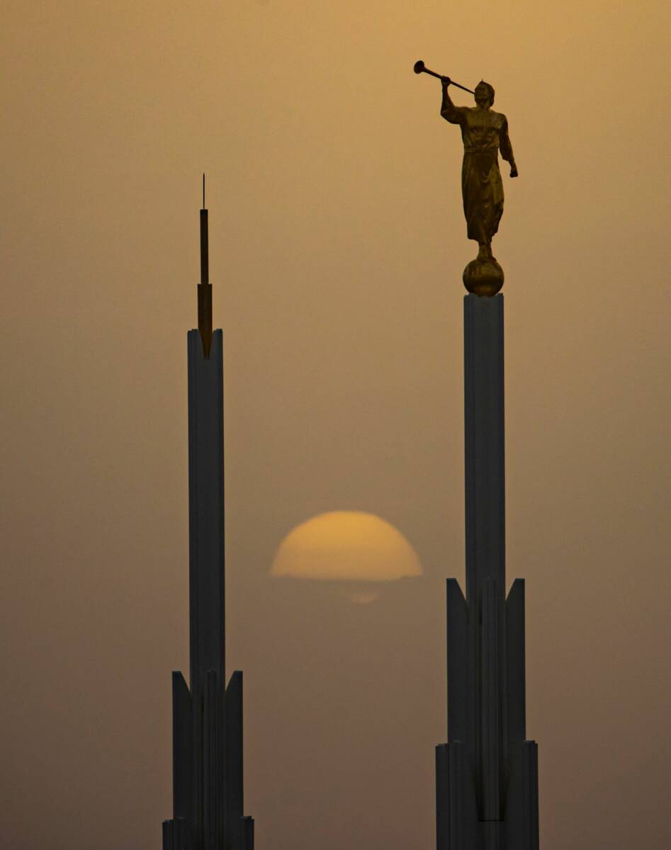 The setting sun is seen partially obscured past the Las Vegas Nevada Temple as winds bring in a ...
