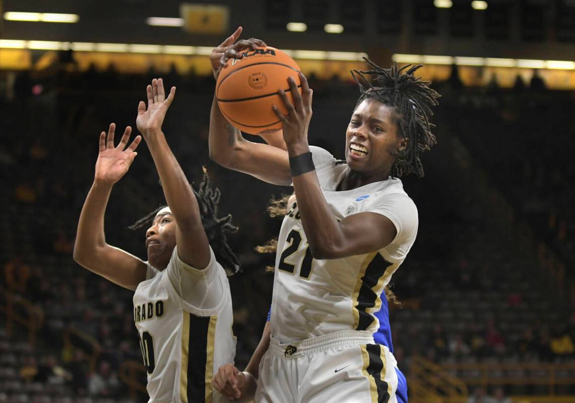 Colorado forward Mya Hollingshed (21) grabs a rebound with teammate Jaylyn Sherrod (00) during ...