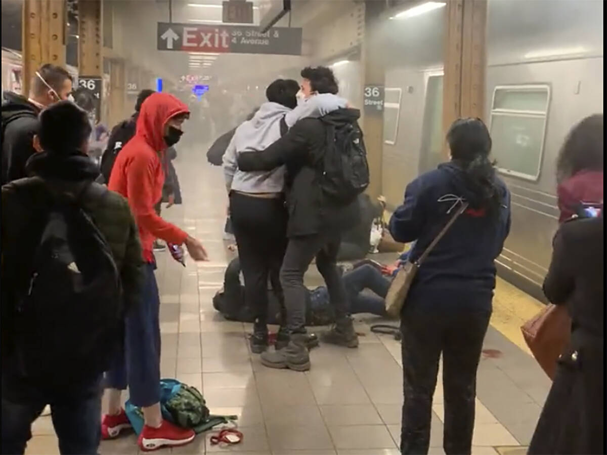 This photo provided by Will B Wylde, a person is aided outside a subway car in the Brooklyn bo ...