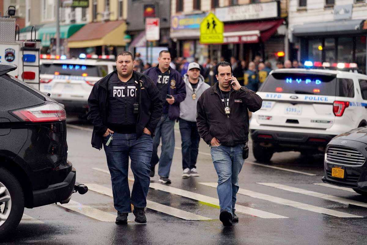 New York City Police Department personnel gather at the entrance to a subway stop in the Brookl ...