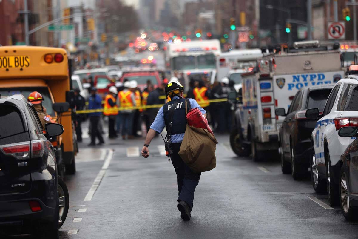 Law enforcement gather near the entrance to a subway stop in the Brooklyn borough of New York, ...