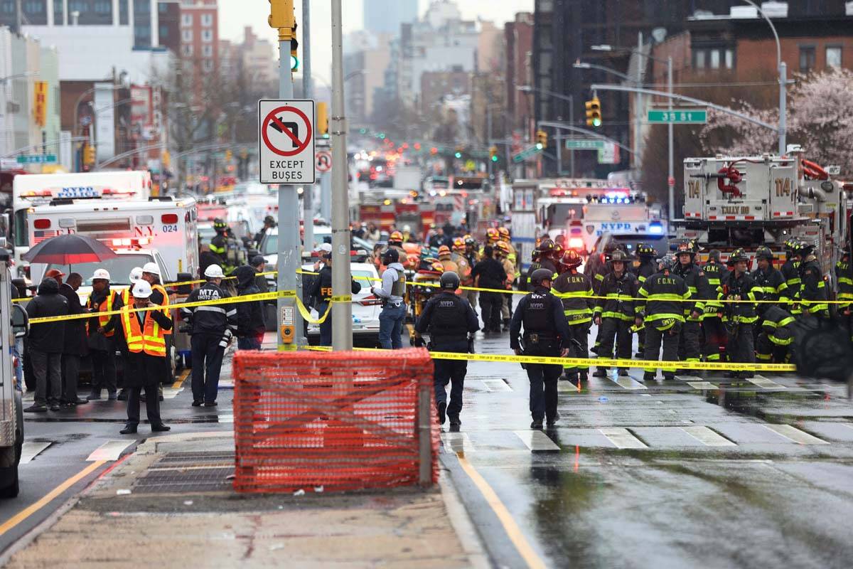 Law enforcement gather near the entrance to a subway stop in the Brooklyn borough of New York, ...