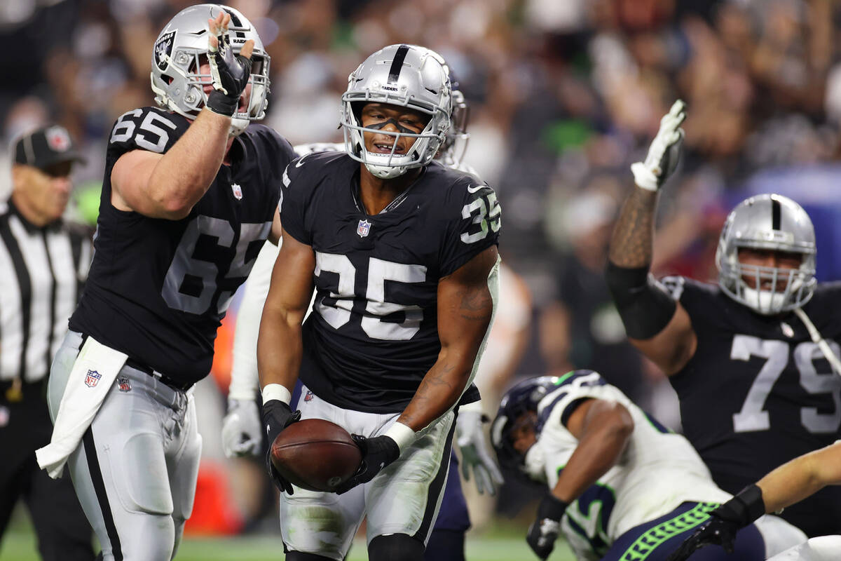 Las Vegas Raiders running back B.J. Emmons (35) reacts after a rushing touchdown, with center J ...