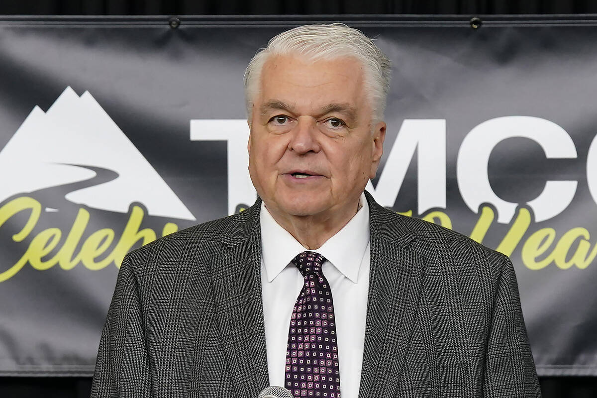 Nevada Gov. Steve Sisolak, a Democrat, right, speaks during a visit to the Pennington Health Sc ...