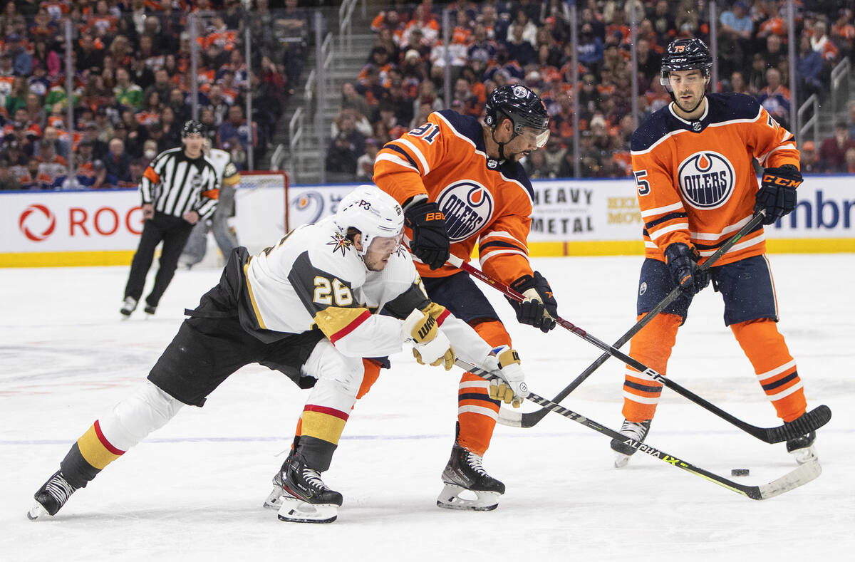 Vegas Golden Knights' William Carrier (28) and Edmonton Oilers' Evander Kane (91) battle for th ...