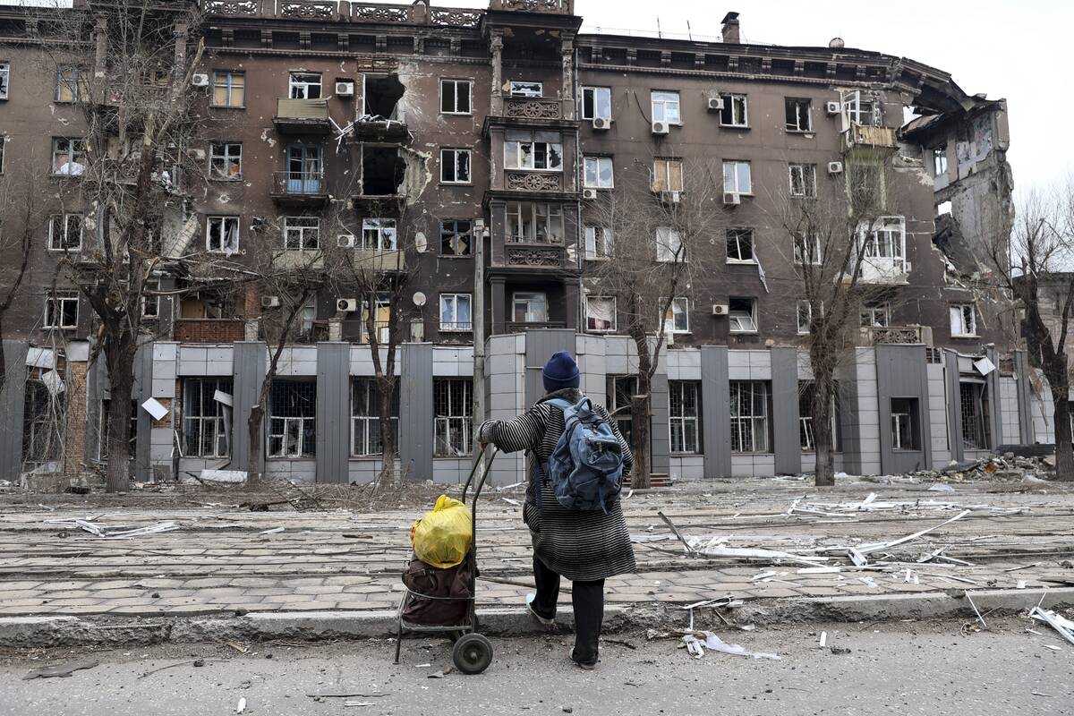 A local resident looks at a damaged during a heavy fighting apartment building near the Illich ...