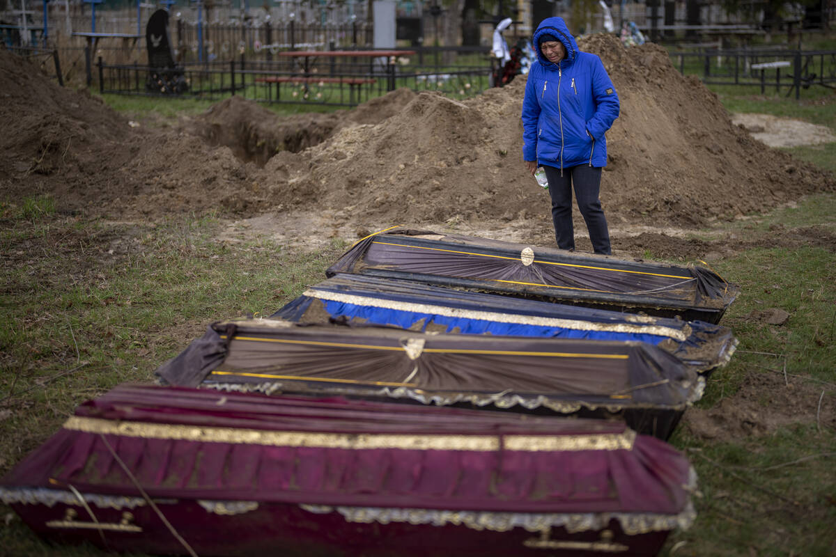 CAPTION CORRECTS LOCATION - Ira Slepchenko, 54, cries next to coffins, one of them with the bod ...