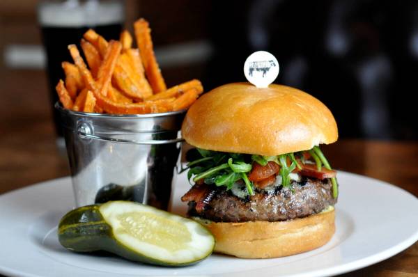 A Gold Standard burger from Holsteins Shakes and Buns in The Cosmopolitan is dressed with aged ...