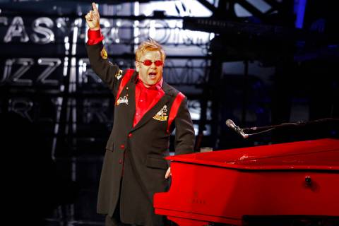 Elton John greets the audience during his final "The Red Piano" show at The Colosseum inside Ca ...
