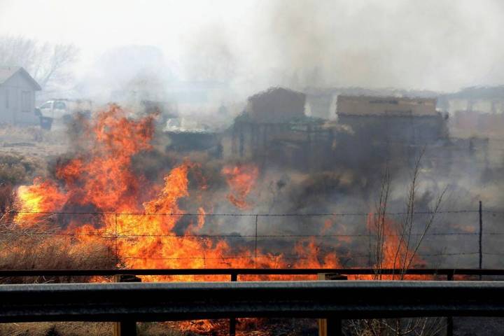 A wind-driven wildfire burns at the edge of U.S. 89 on the outskirts of Flagstaff, Ariz., on Tu ...