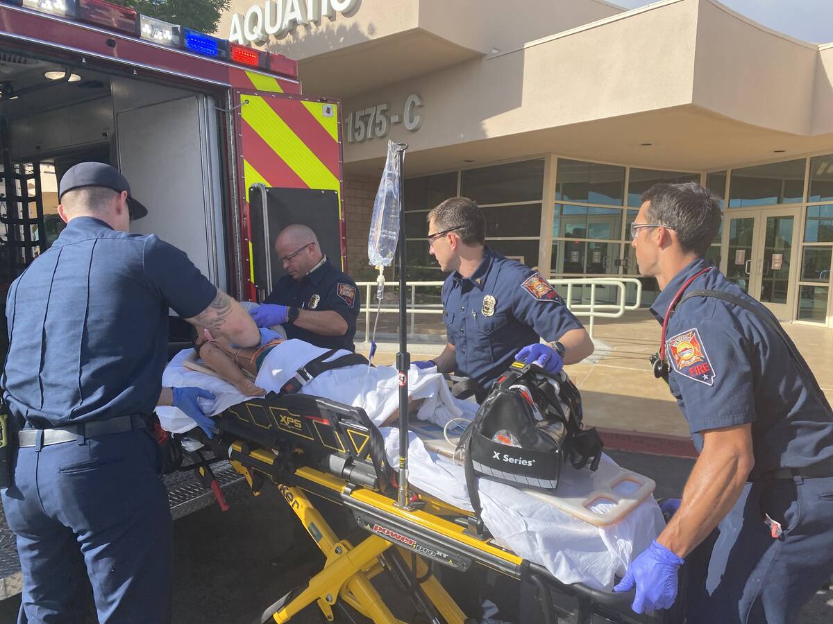 Henderson paramedics and firefighters practice transporting a patient to the hospital as part o ...