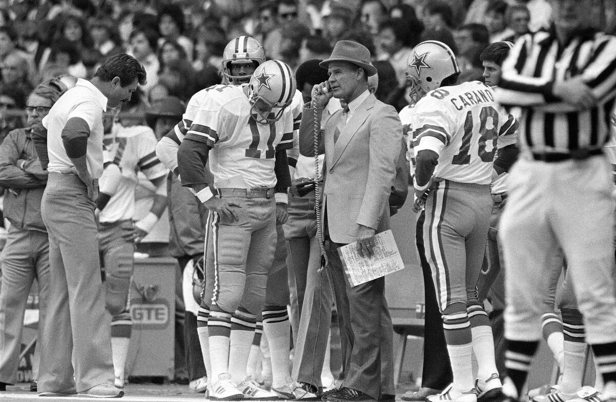 Cowboys head coach Tom Landry, center, exchanges information with spotters during the game with ...