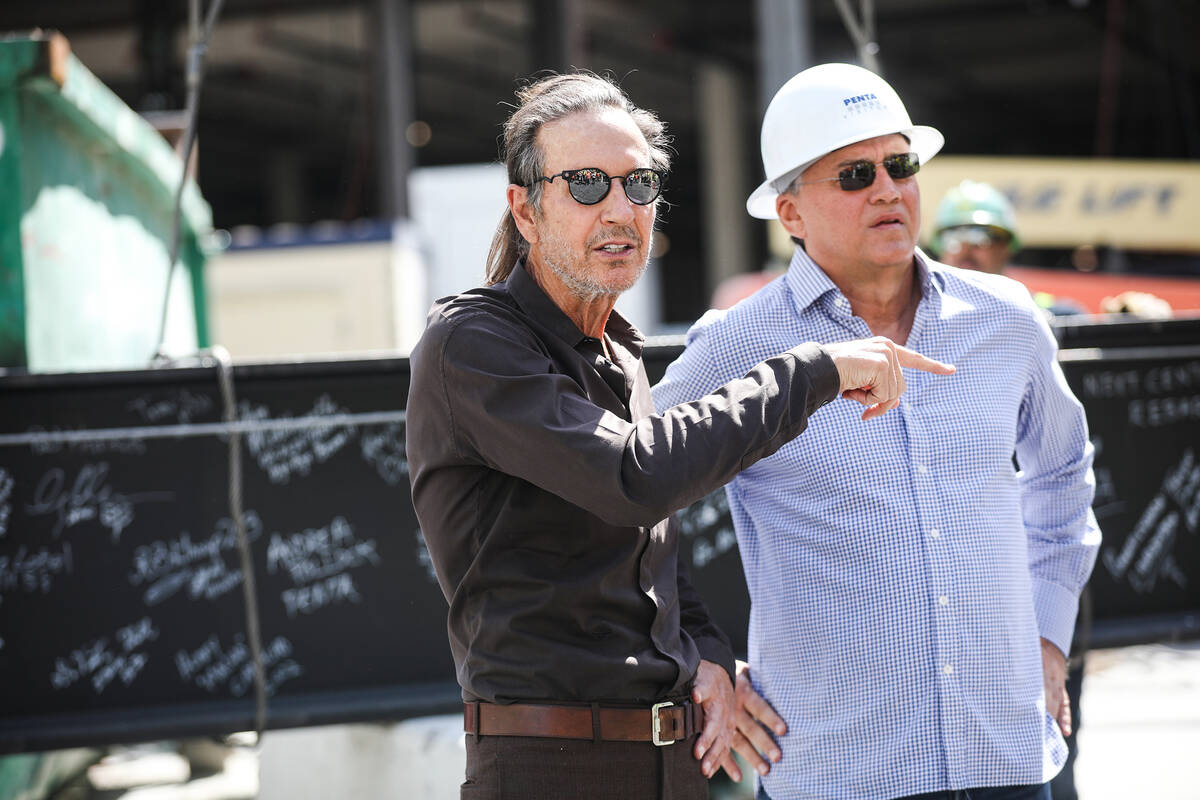 Developer partners Brett Torino, left, and Paul Kanavos, right, speak to workers at the constru ...