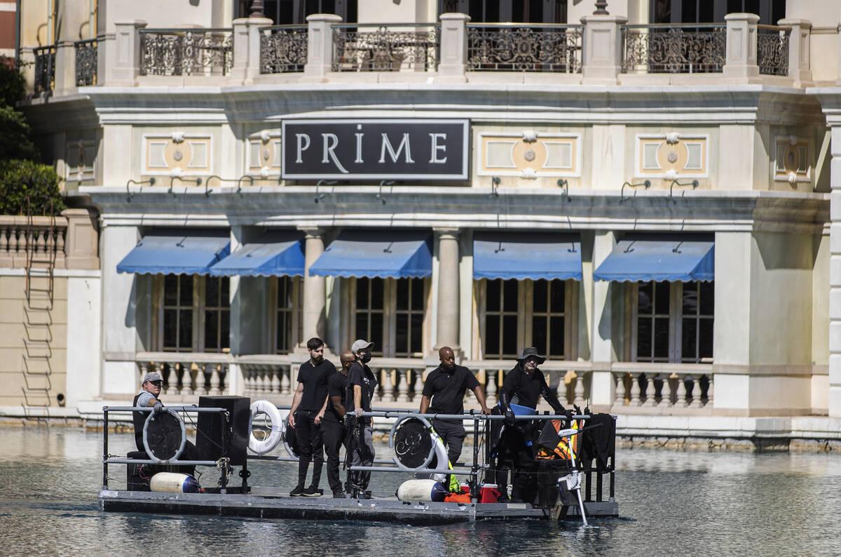 Workers scan the perimeter of the NFL Draft Red Carpet Stage at the Bellagio Fountains on Tuesd ...