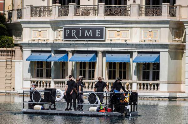 Workers scan the perimeter of the NFL Draft Red Carpet Stage at the Bellagio Fountains on Tuesd ...