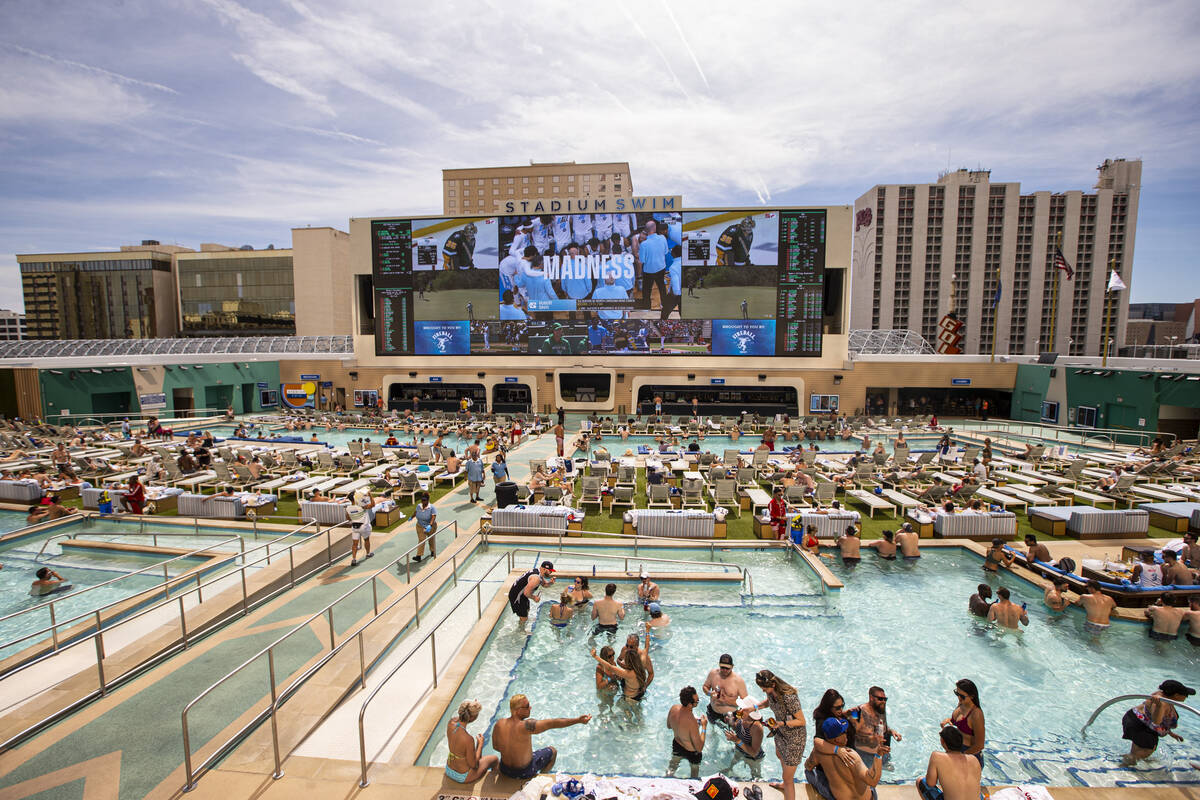 In this March 27, 2022, people watch as North Carolina takes on St Peter's in the Elite 8 round ...