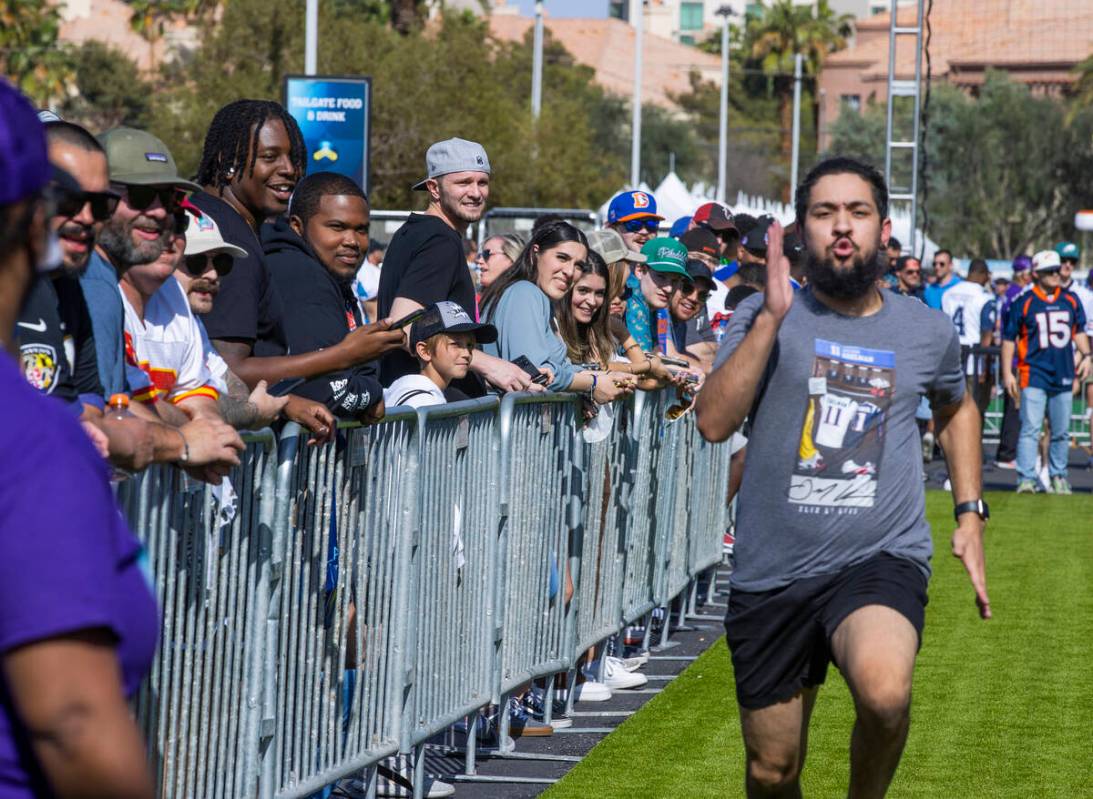 Fans look on as another runs a 40-yard dash within the Draft Experience on the first day events ...