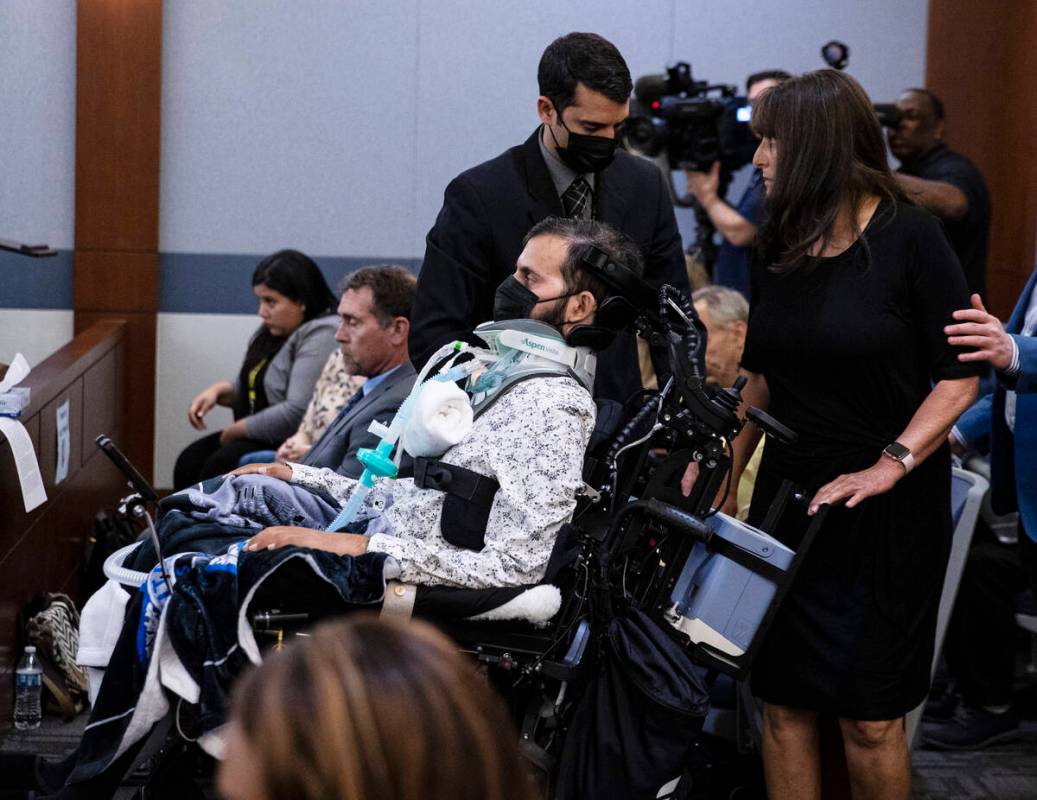 Sharon Neville walk past her son Metro officer Shay Mikalonis, left in a wheelchair, as she pre ...