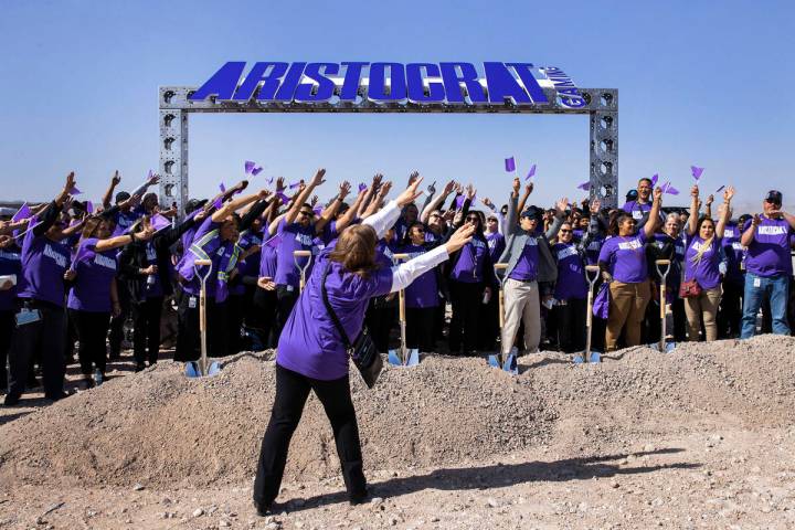 Aristocrat Gaming employees make a wave as they pose for a photo prior to the start of the grou ...