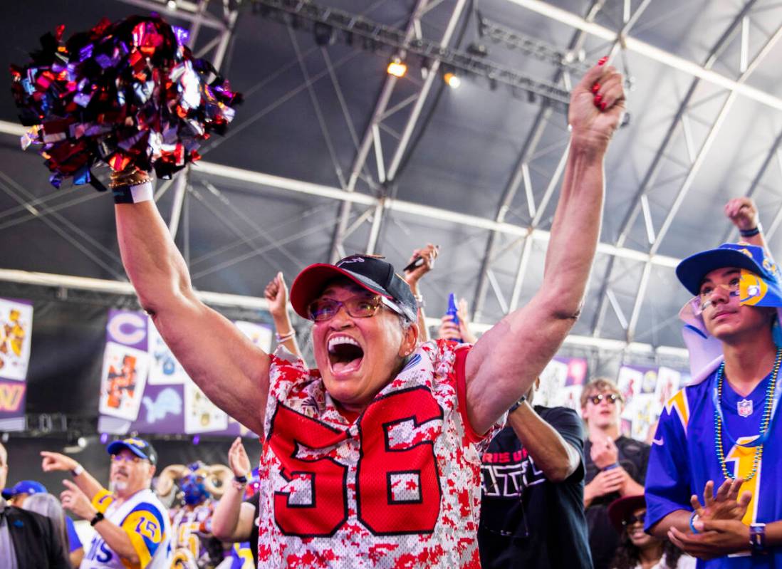 Lizzette Strickland, from Atlanta, Ga., celebrates after winning an autographed football after ...