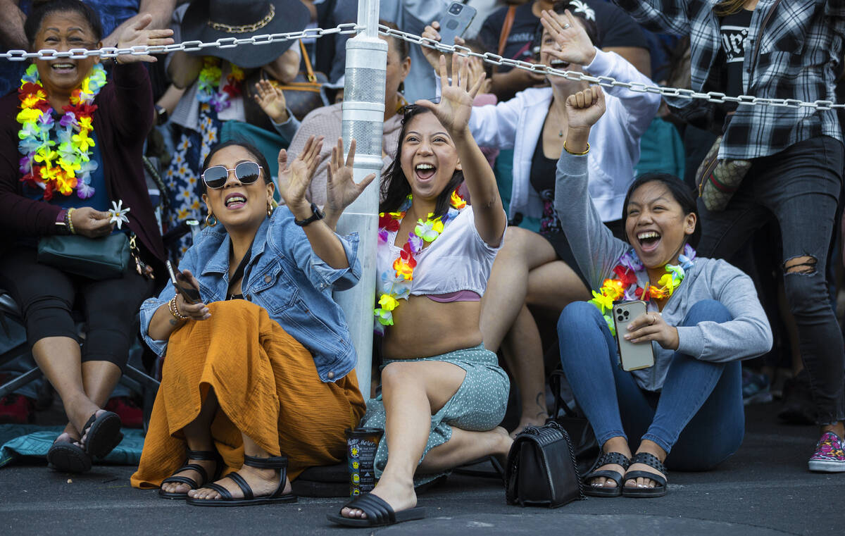 Angela Sevilla, left, Gabby Angeles and Kales Bautista wave to dancers during Lei Day, a new pa ...