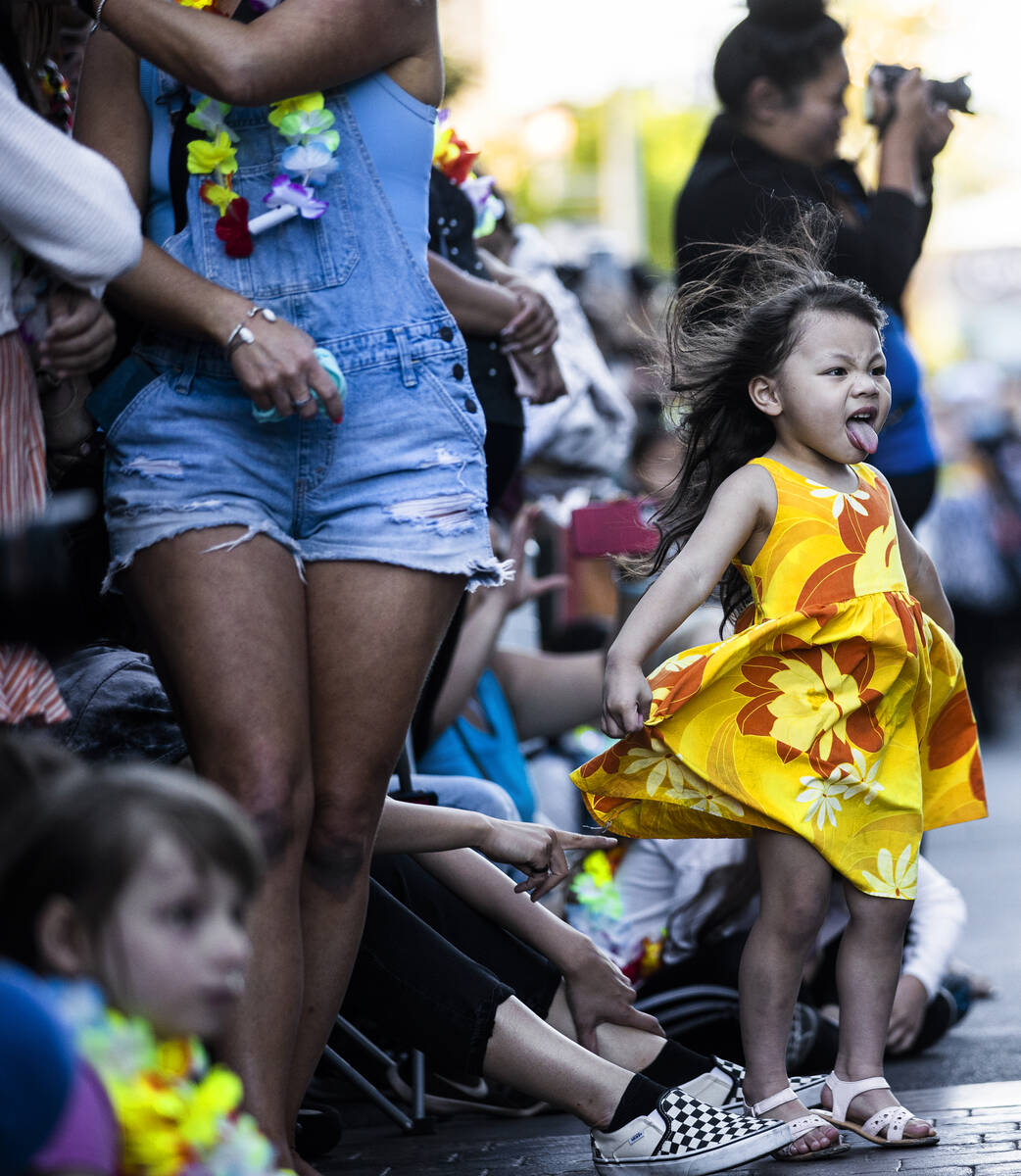Sofia Alani Espiritu-Simmons, 2, acknowledges the dancers in the parade during Lei Day, a new e ...