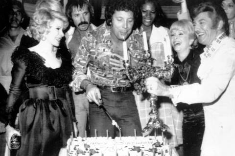 Tom Jones, center, blows out candles at a surprise birthday party at Caesar's Palace, Las Vegas ...