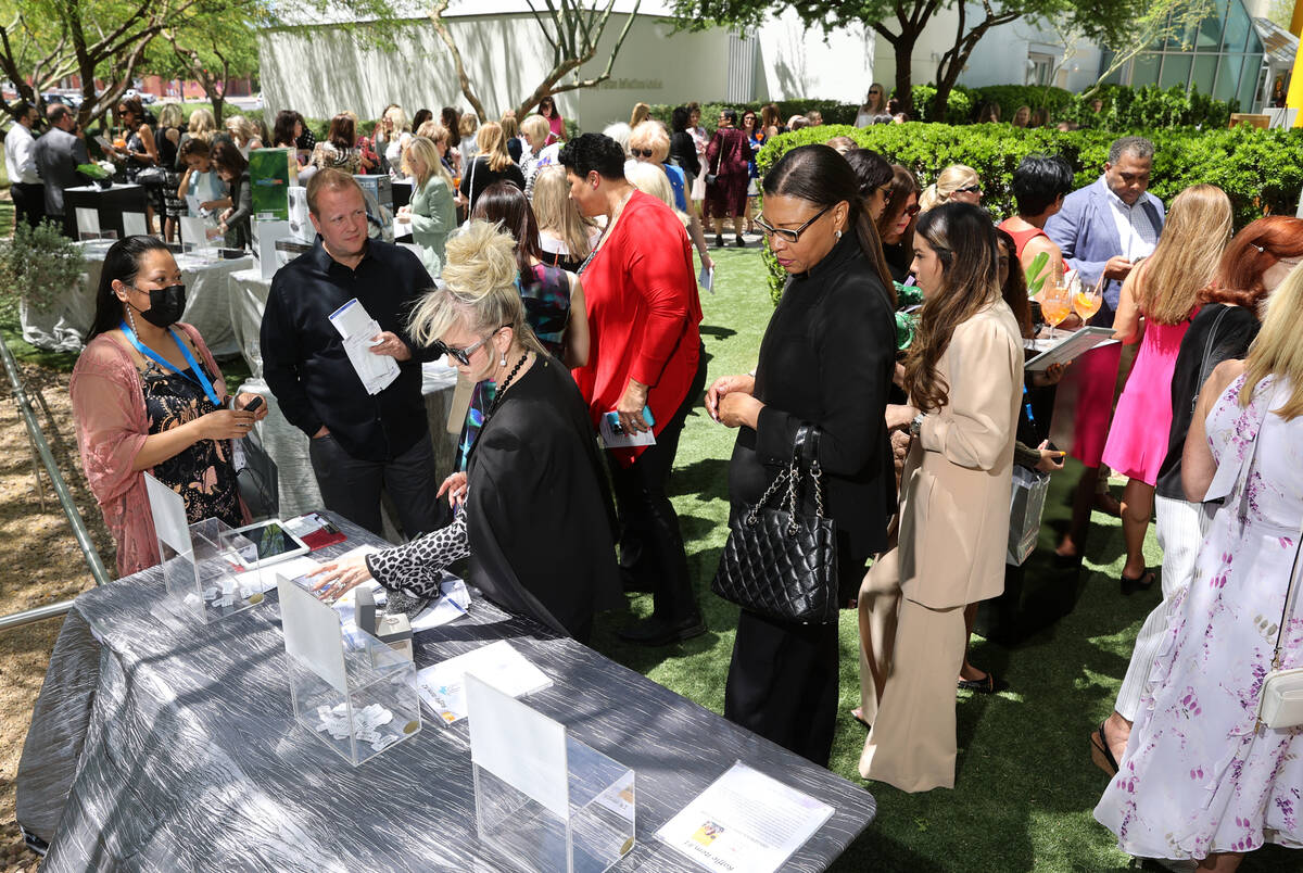 Guests browse auction items during a Mother's Day luncheon with Maria Shriver at Cleveland Clin ...
