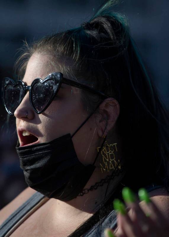 Amber Taylor, of Las Vegas, wears earrings saying “trust no man” during a rally i ...