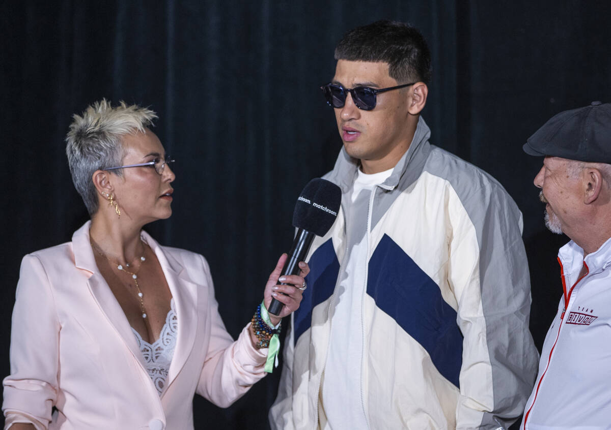 Dmitry Bivol, center, talks with announcer Claudia Trejos, left, during boxing Grand Arrivals a ...