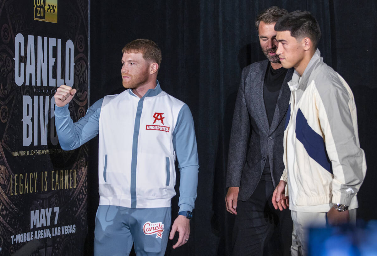 Canelo Alvarez, left, looks to fans with Dmitry Bivol, right, and Matchroom Boxing Chairman Edd ...