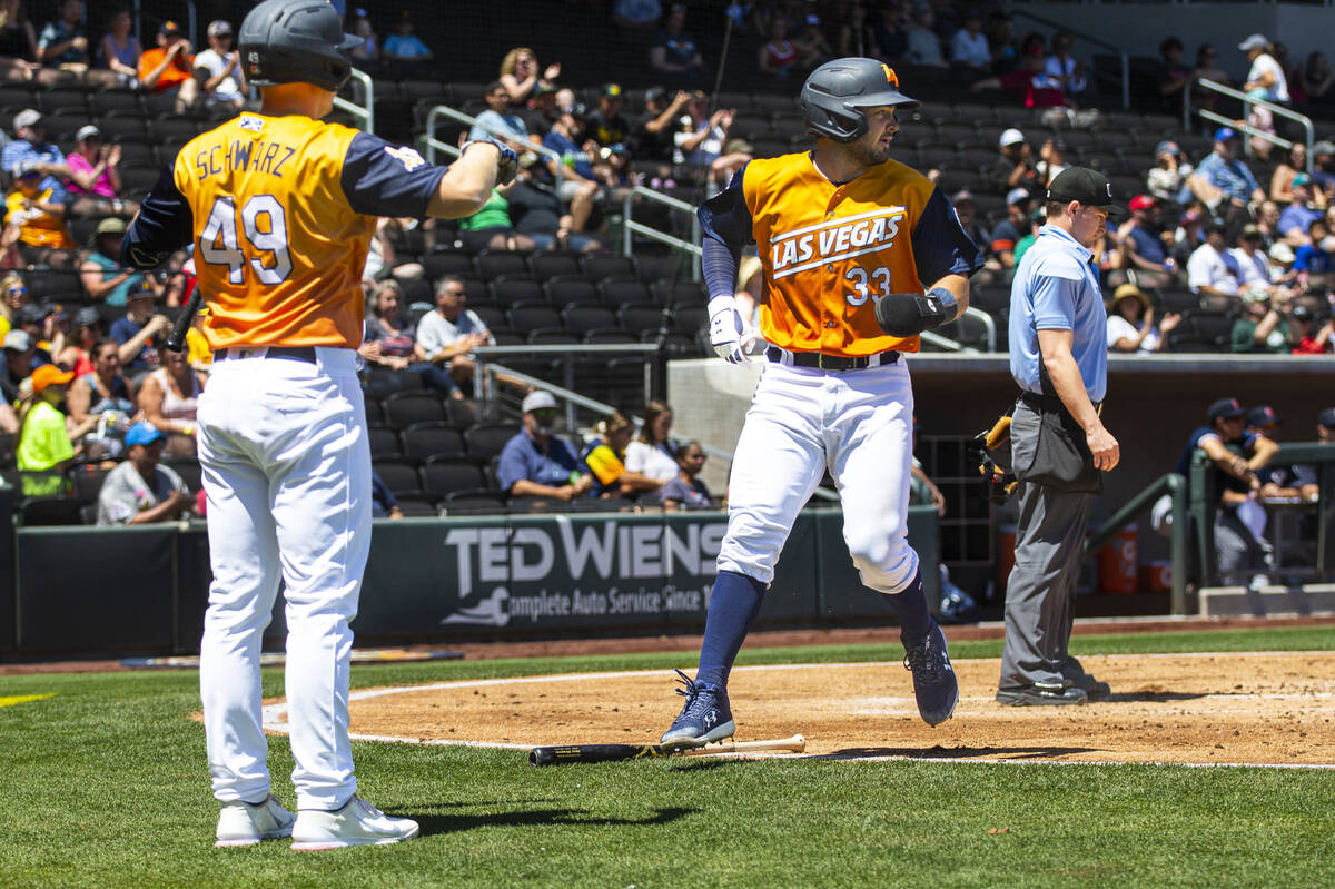 Las Vegas Aviators catcher Shea Langeliers (33) scores a run against the Tacoma Rainiers during ...