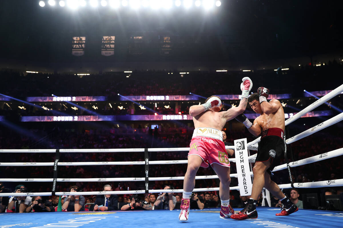 Saul “Canelo” Alvarez, left, battles Dmitry Bivol in the second round of the WBA super ligh ...