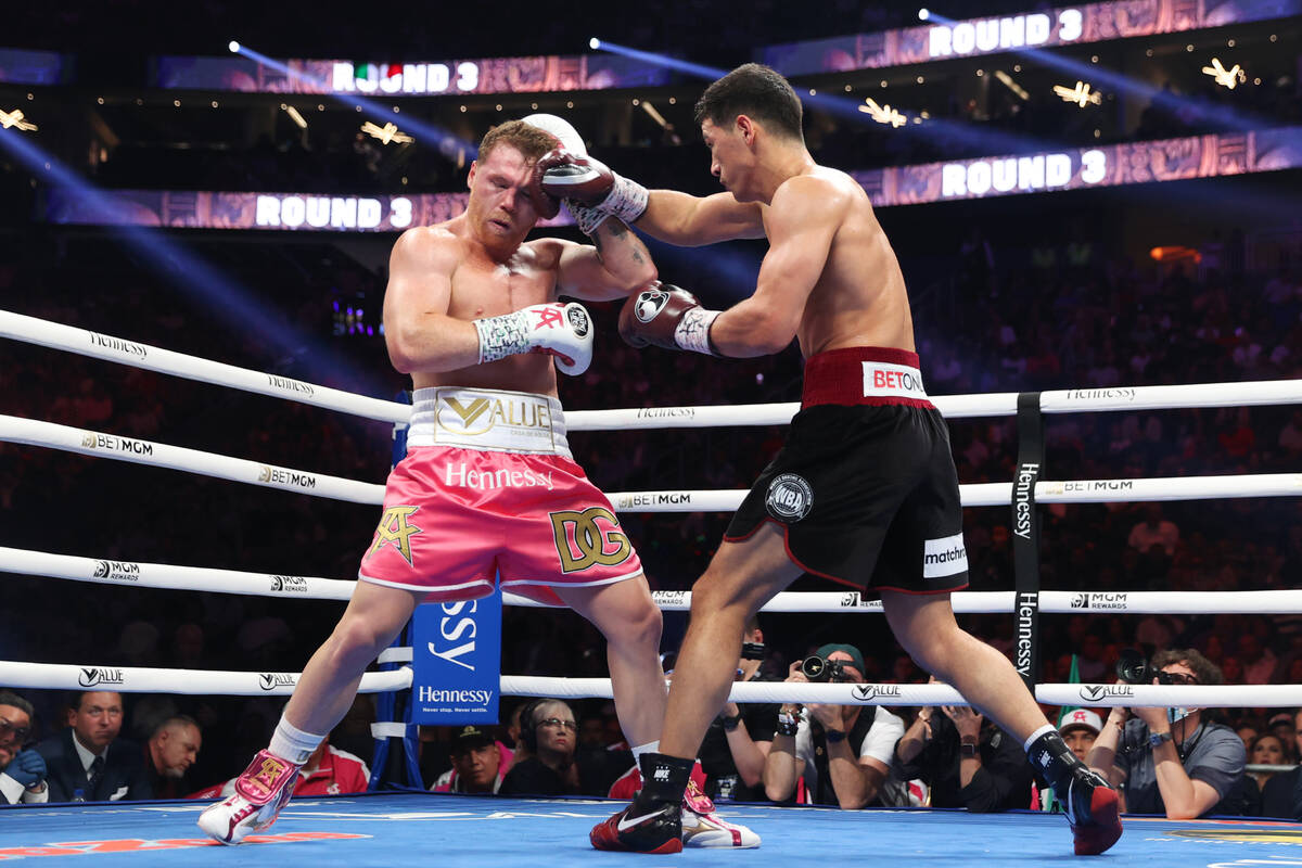 Saul “Canelo” Alvarez, left, battles Dmitry Bivol in the third round of the WBA s ...