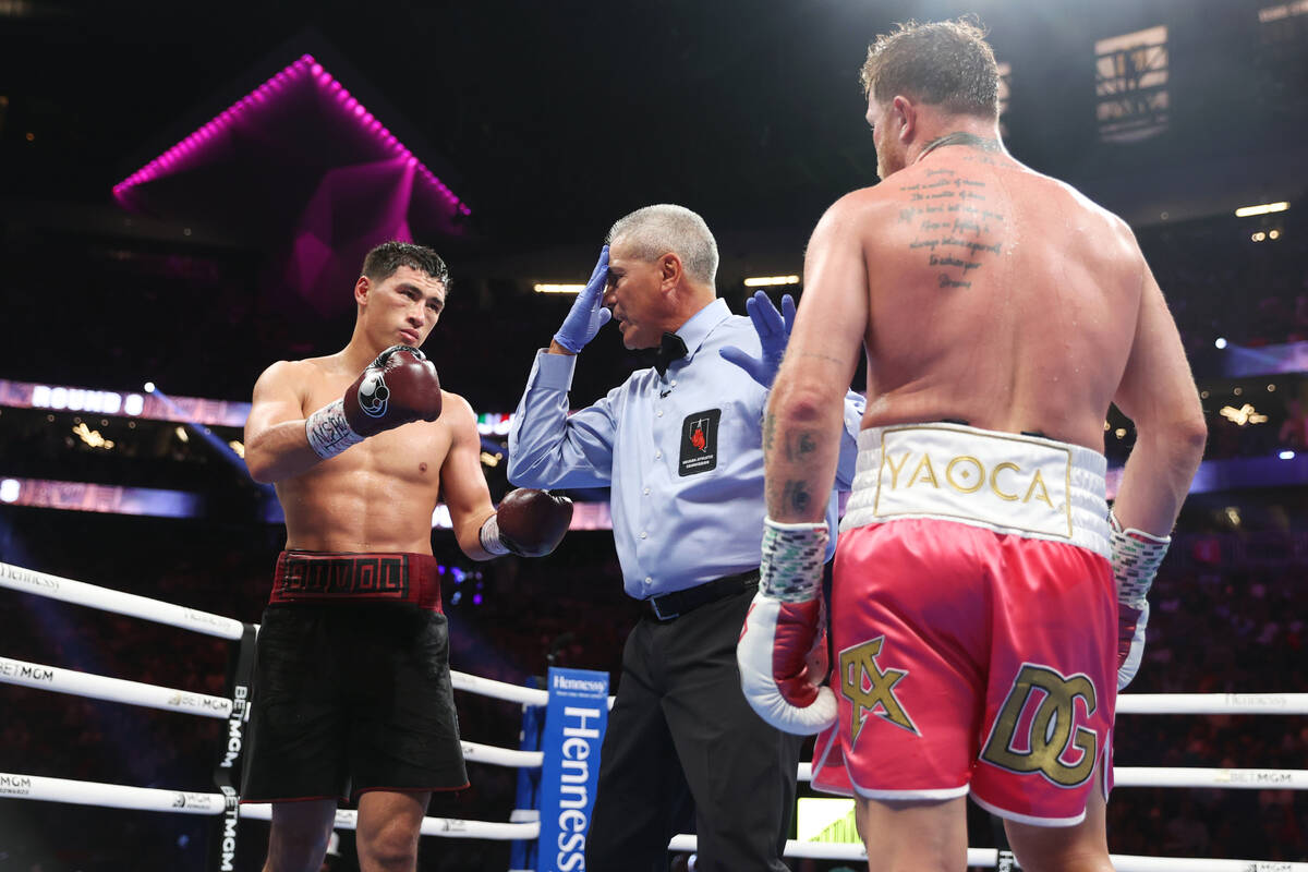 Dmitry Bivol, left, is warned by the referee during the eight round of the WBA super light heav ...