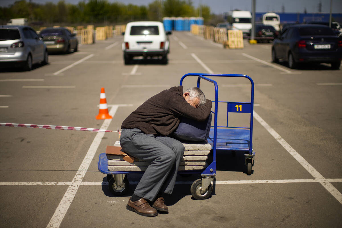 A man who fled from a small village near Polohy rests upon his arrival to a reception center fo ...