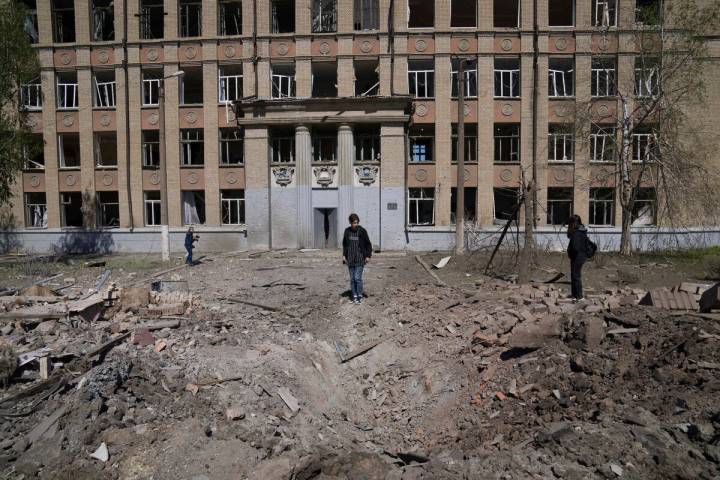 CAPTION CORRECTS THE LOCATION - A woman looks on a crater of an explosion after Russian airstri ...