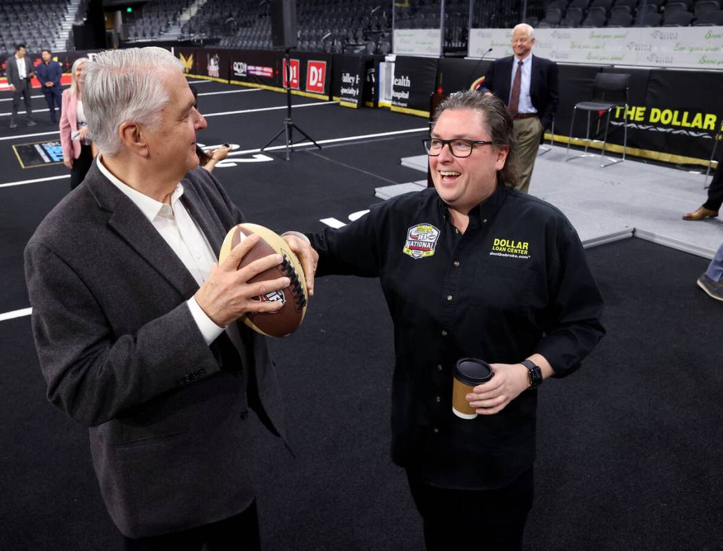 Nevada Gov. Steve Sisolak, left, and Dollar Loan Center Founder and CEO Chuck Brennan play with ...