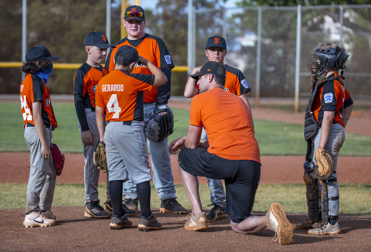Giants head coach counsels his players on the pitcher’s mound during a game versus the B ...