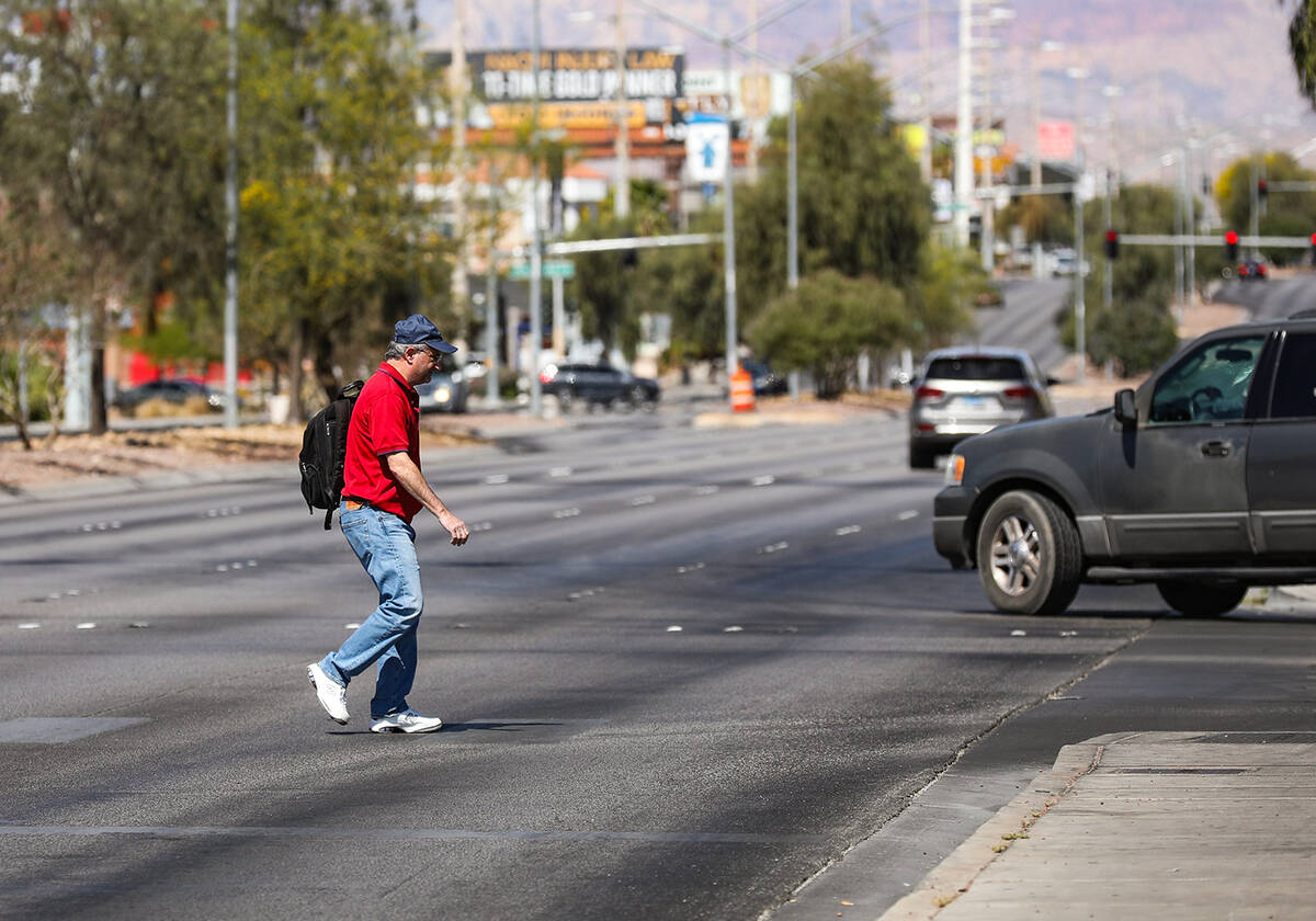 A pedestrian crosses Sahara Avenue at Paseo Del Prado in Las Vegas, Sunday, May 15, 2022. Safet ...