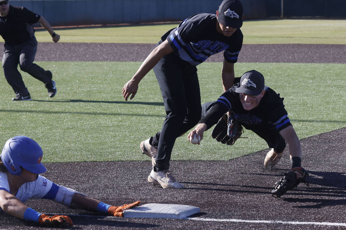 Bishop GormanÕs Easton Shelton, left, slides safely into the first base as Basic's Cooper She ...