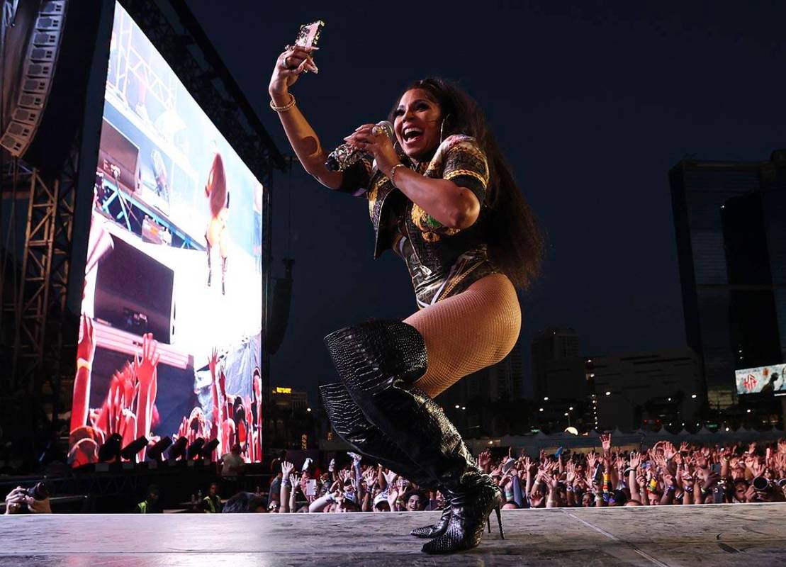 Ashanti records with her phone during the Lovers & Friends music festival on Saturday, May ...