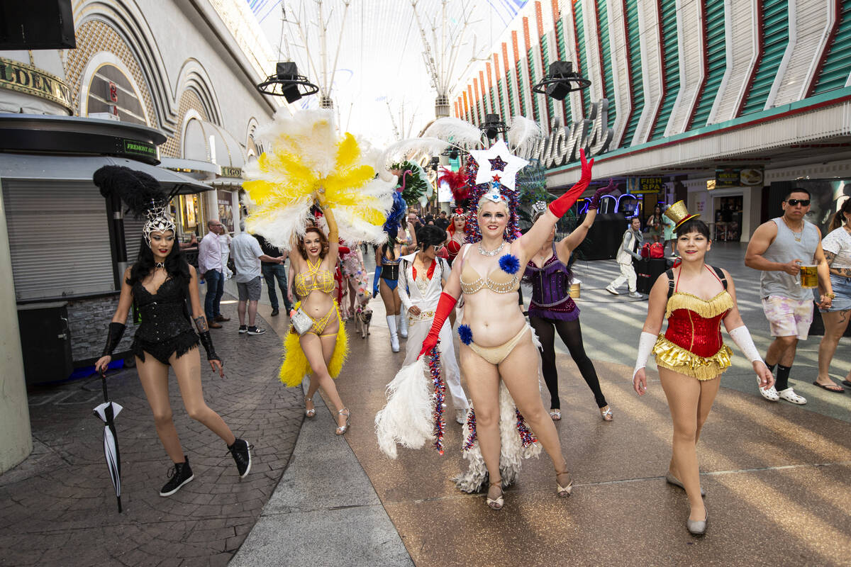 Participants in the Las Vegas Showgirl parade walk along the Fremont Street Experience on Sunda ...