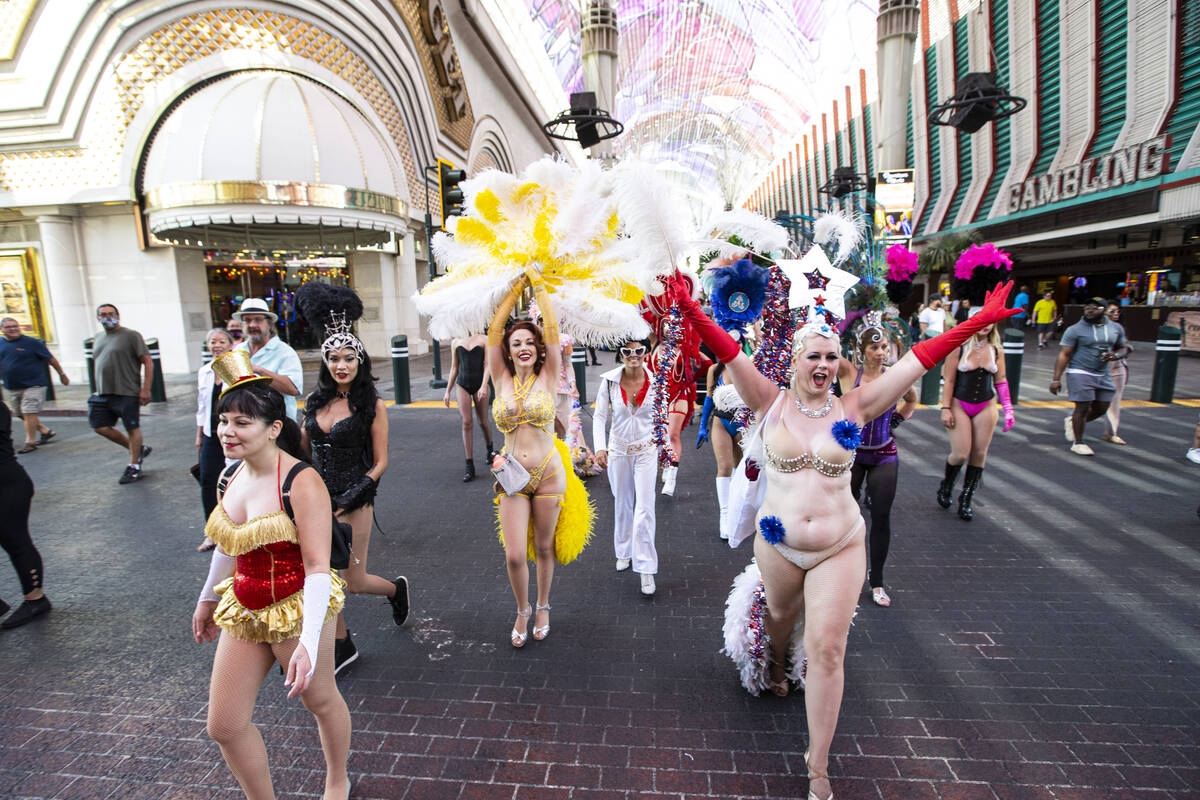 Participants in the Las Vegas Showgirl parade walk along the Fremont Street Experience on Sunda ...