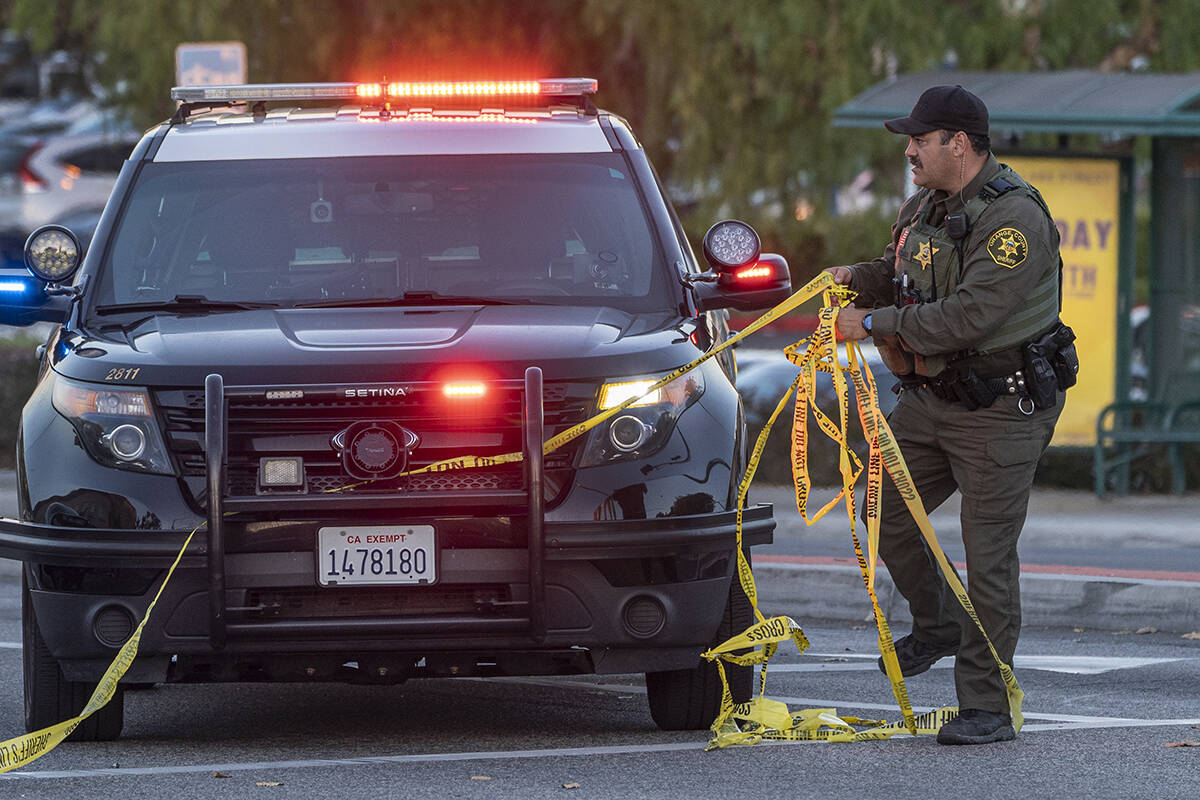 A Orange County Sheriff deputy removes yellow tape from a vehicle outside the Geneva Presbyteri ...