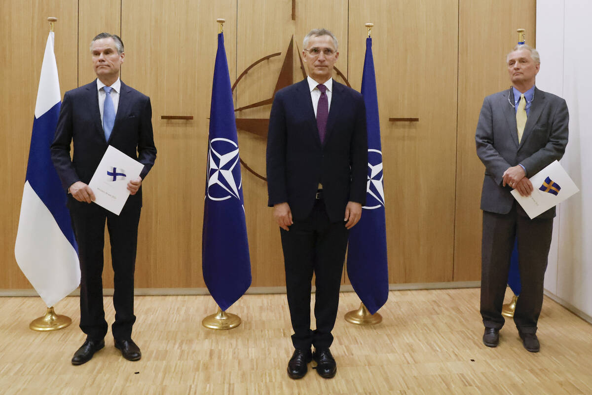 Finland's Ambassador to NATO Klaus Korhonen, left, NATO Secretary-General Jens Stoltenberg and ...