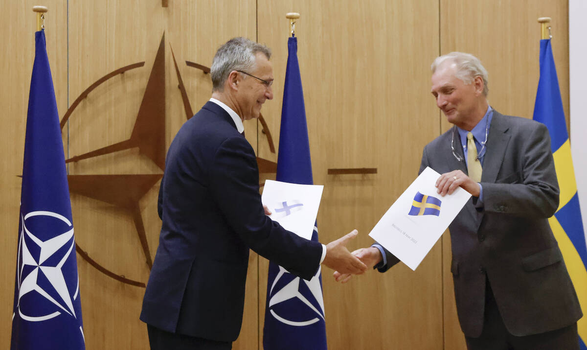 NATO Secretary-General Jens Stoltenberg and Sweden's Ambassador to NATO Axel Wernhoff shake han ...