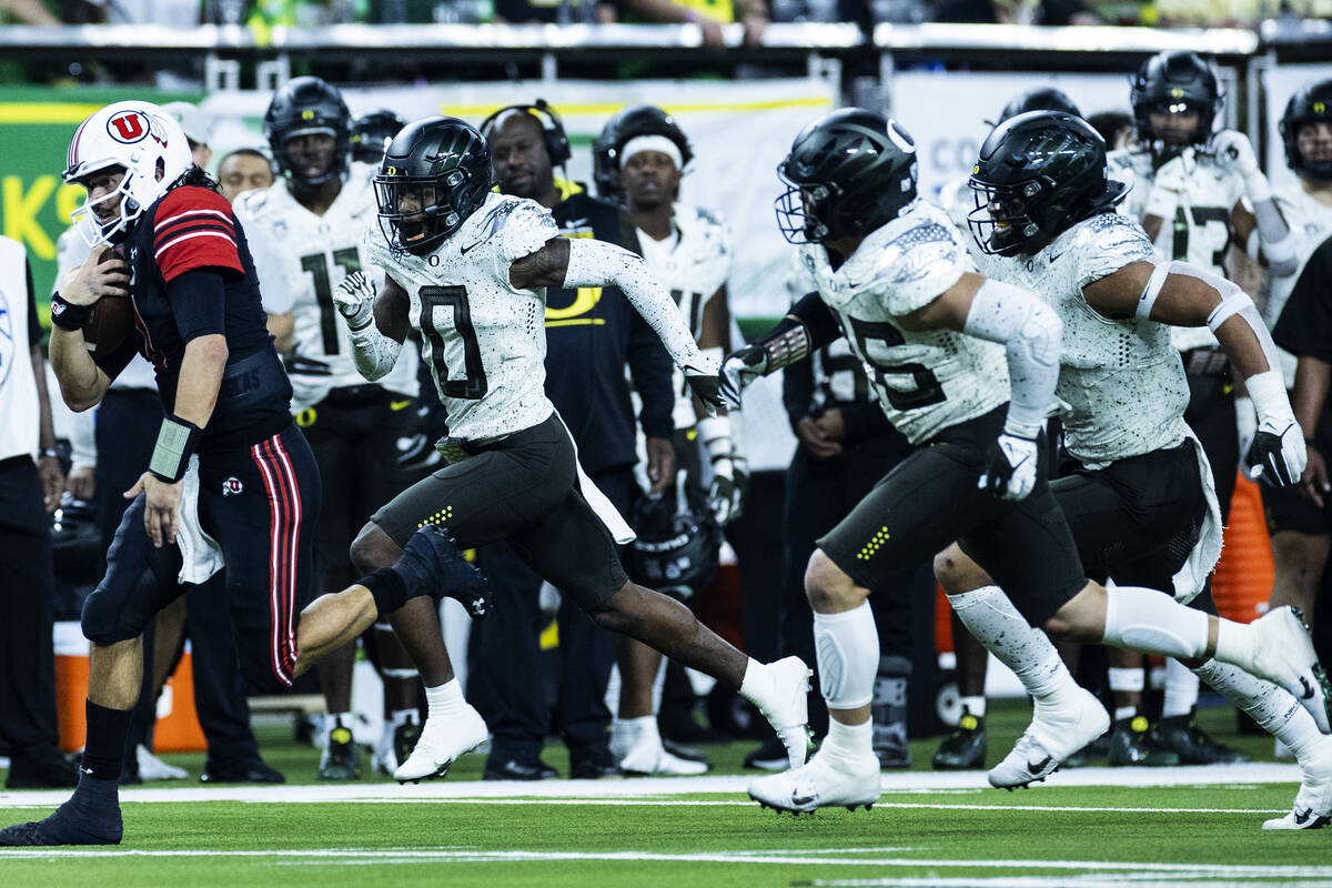 Utah Utes quarterback Cameron Rising (7) surrounded by Oregon Ducks players as he runs with the ...
